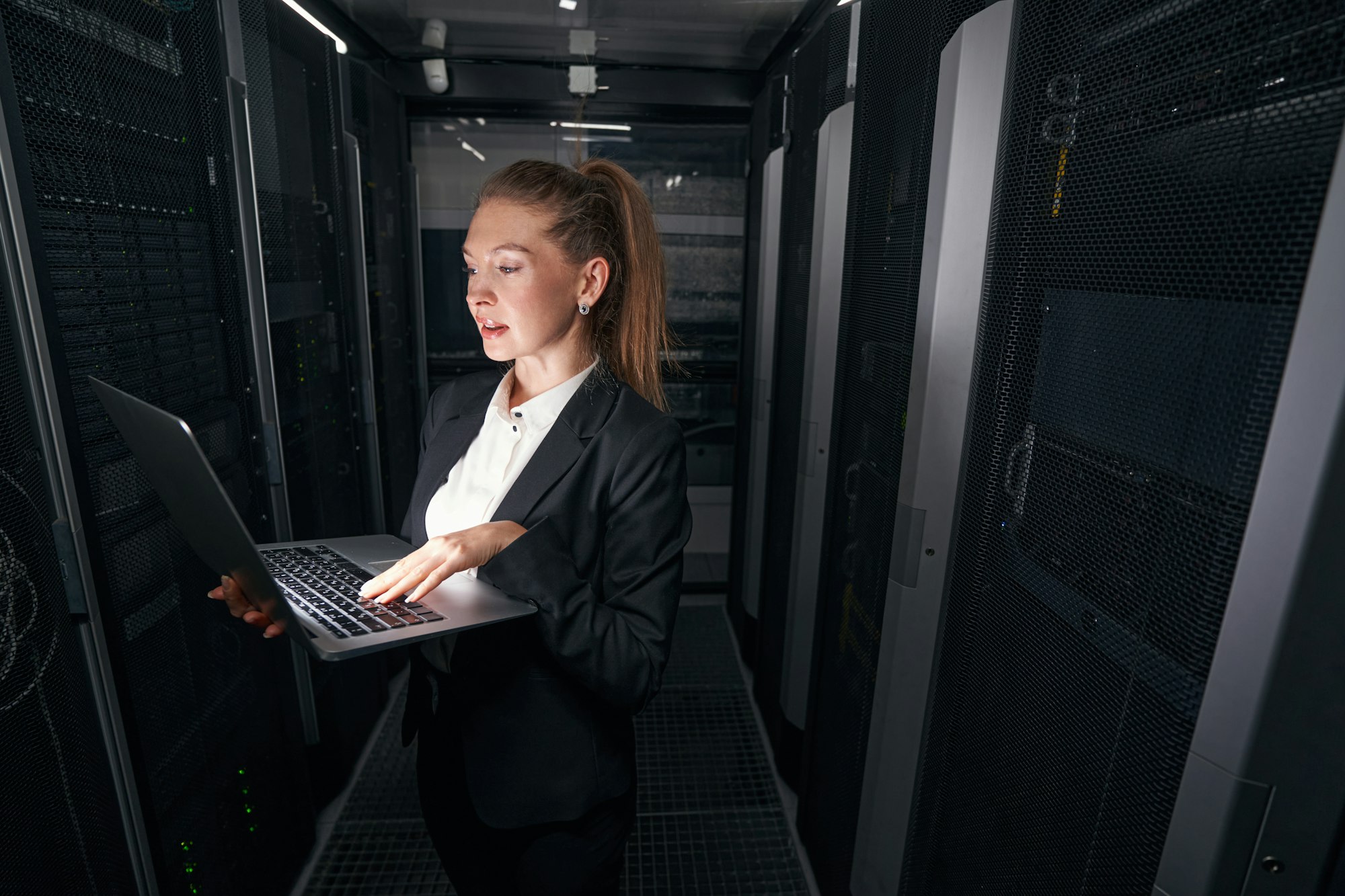 Female IT network manager working in server room